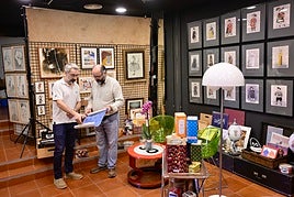 José Carlos Nievas, a la derecha, muestra a Rubén Caral un papel de forrar armarios del siglo XIX.