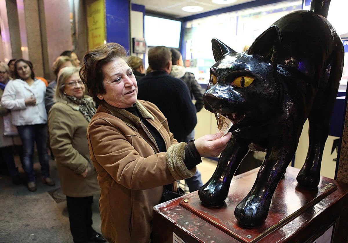 Una mujer frota un décimo por el gato negro de la administración de la calle Trapería de Murcia, en una foto de archivo.