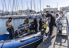 Un grupo de aficionados al buceo recreativo se preparan para salir al mar en una zódiac con el club Planeta, en el puerto de Cabo de Palos.