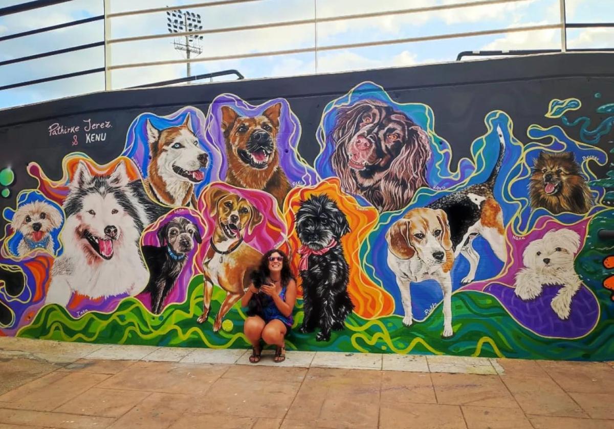 Patricia Jerez con Suca, junto a su retrato en el mural de La Rambla.