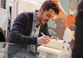 J. J. Arevi, firmando uno de sus libros.