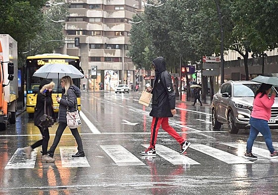 Varias personas pasean por Murcia en un día lluvioso, en una imagen de archivo.