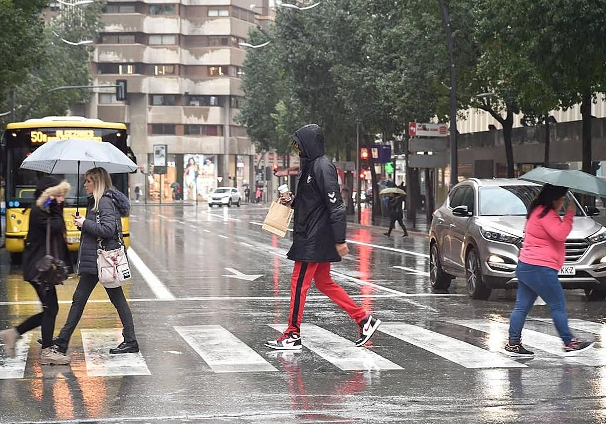Varias personas pasean por Murcia en un día lluvioso, en una imagen de archivo.