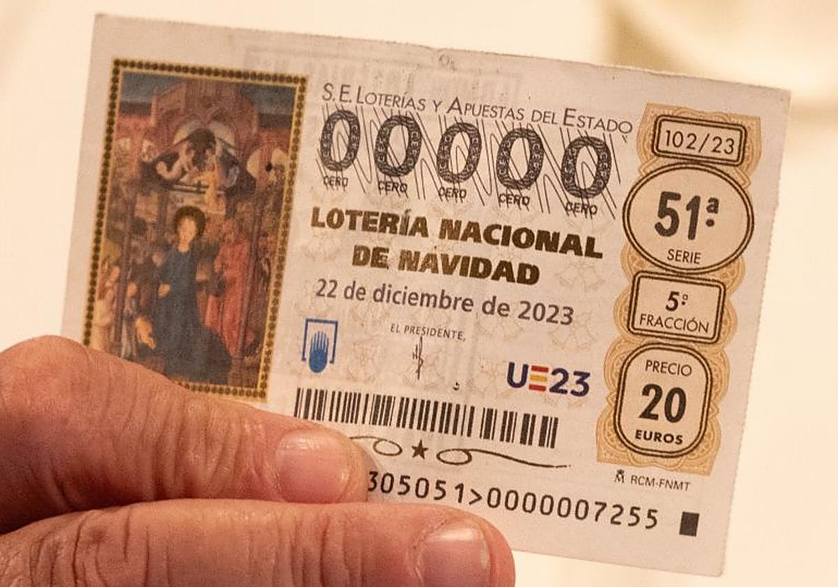 Un sacerdote sujeta un décimo de la Lotería de Navidad