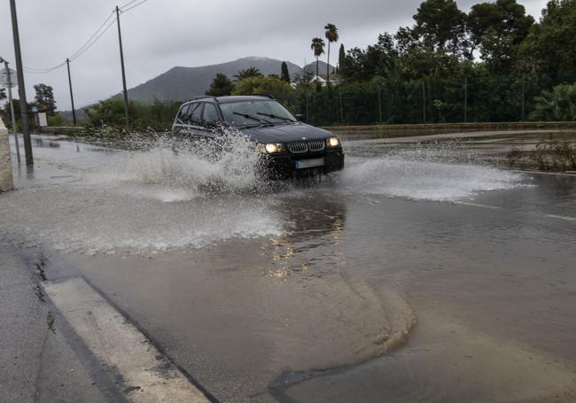 Un coche pasa por una calle inundada en Cartagena.