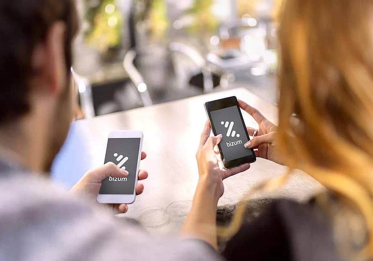 Dos personas utilizan Bizum para realizar un pago.