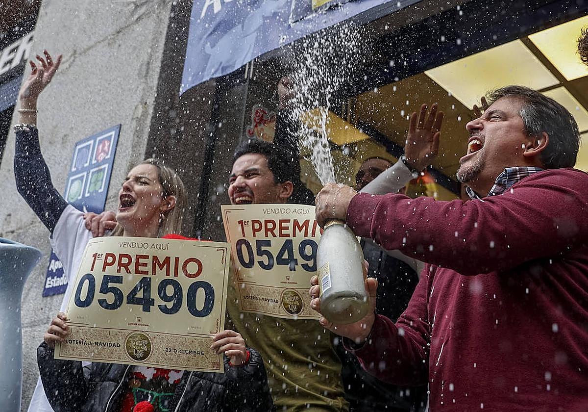 Varias personas celebran haber ganado el primer premio de la Lotería de Navidad de 2022.