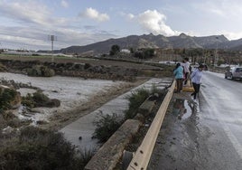 Unas vecinas observan el importante caudal de la rambla de Las Moreras de Mazarrón durante la alerta naranja del pasado domingo.