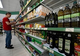 Un hombre compara precios en un supermercado.