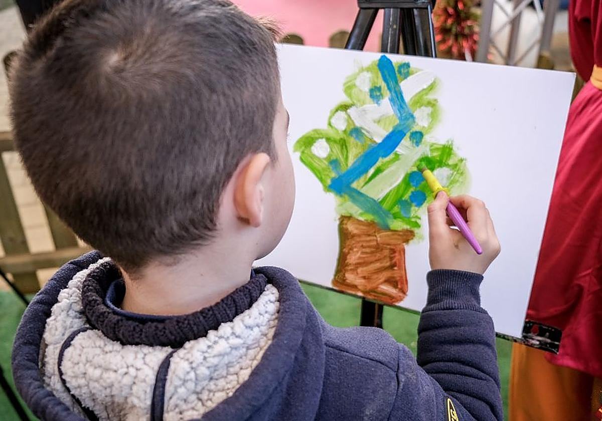 Un niño participa en un taller de pintura en las escuelas de Navidad.