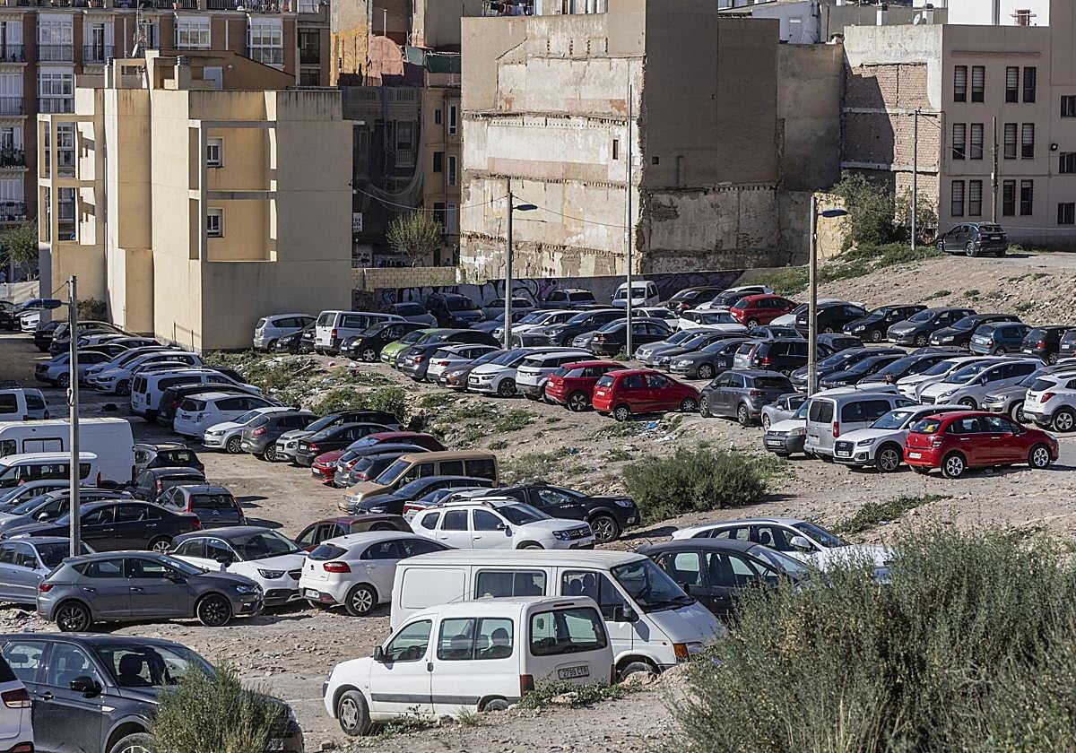 Vehículos estacionados en los desnivelados solares del Monte Sacro, llenos de maleza y basura.