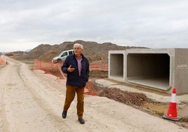 El presidente de la asociación de vecinos de Torrecilla camina junto a los bloques de hormigón para el paso del agua en la rambla de la Torrecilla. GONZALO J. MARTÍNEZ / AGM