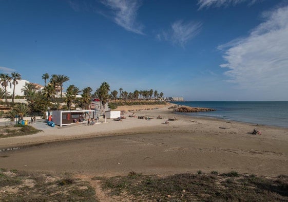 Bañistas toman el sol en la playa de Cala Estaca, este miércoles, junto al puesto de socorrismo de este arenal oriolano.