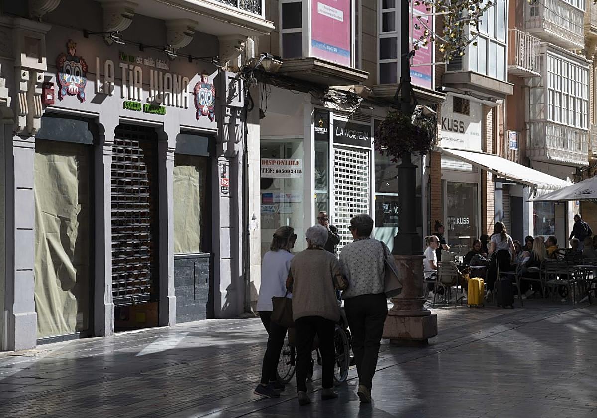 Tres mujeres pasan junto La Tía Juana, cerrado hace una semana.
