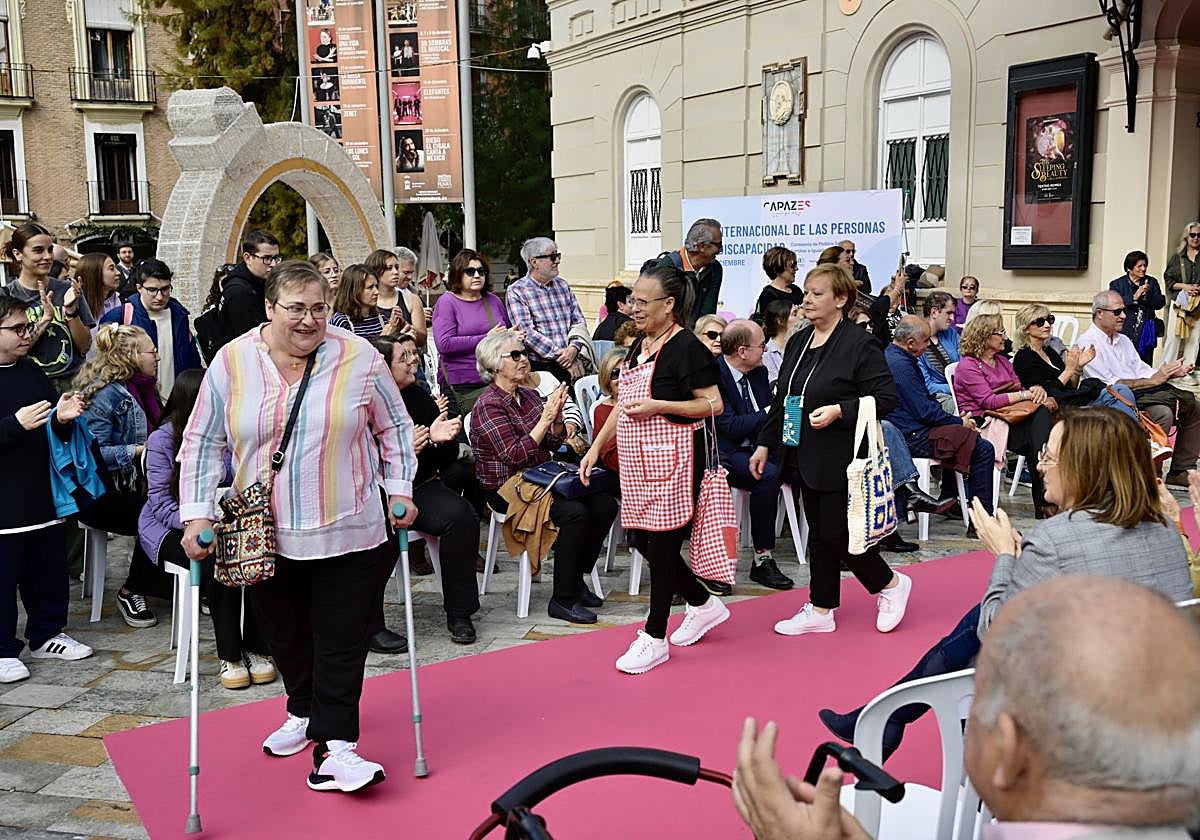 Varias personas participan en el desfile de moda.