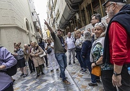 Un guía oficial, con un grupo, en la calle Mayor.