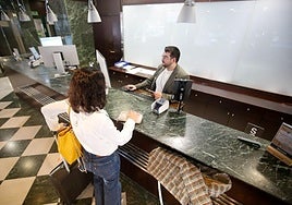 Una clienta entrega su DNI en la recepción del hotel Amistad de Murcia, ayer.