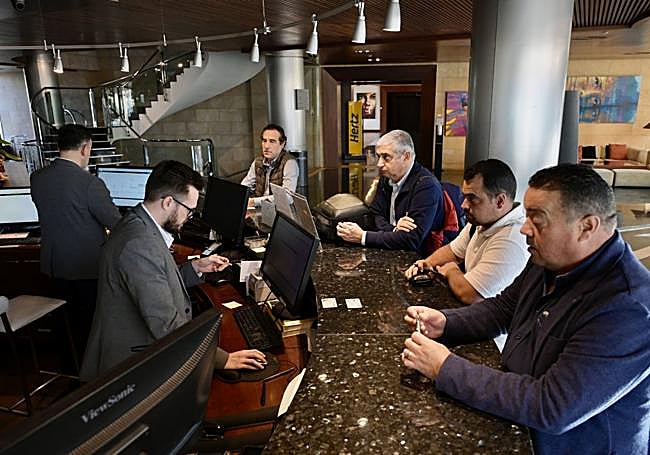 Un grupo de clientes del hotel Nelva de Murcia registrándose a su llegada este lunes.