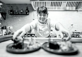 Pilar Olivares saca dos platos de la cocina del restaurante.