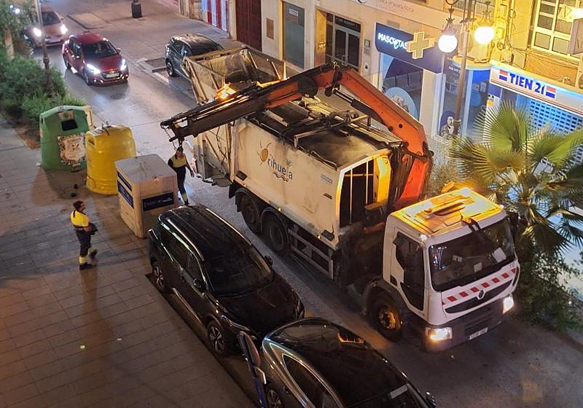 Un camión de basura vacía un contenedor de selectiva en la calle Obispo Rocamora.