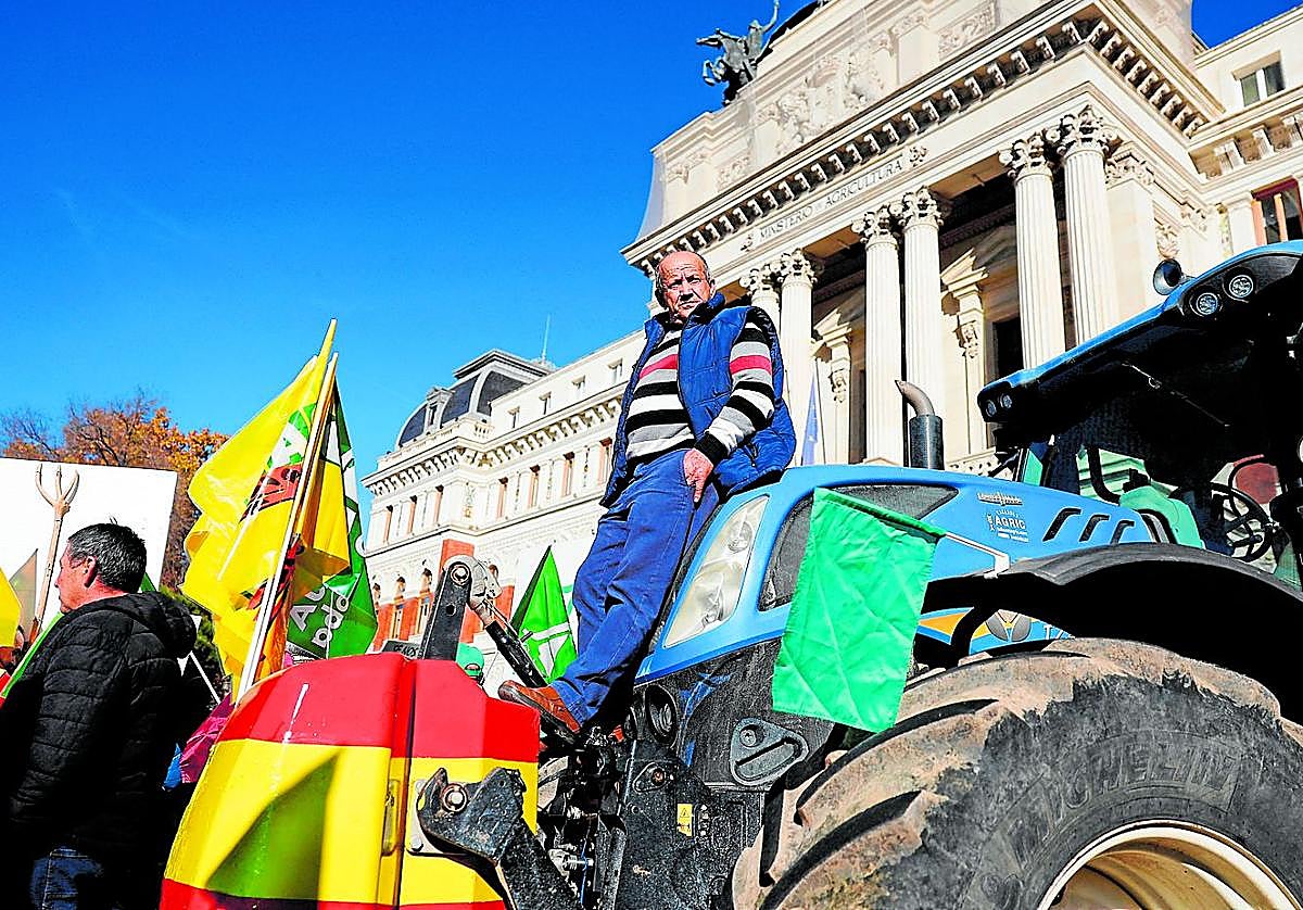 Un agricultor subido a un tractor durante la protesta que tuvo lugar este lunes por la mañana frente al Ministerio de Agricultura en Madrid.