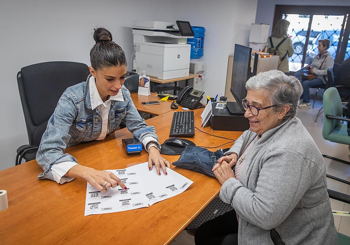 Una mujer adquiere presencialmente un bono consumo en las dependencias de Concejalía de Comercio.