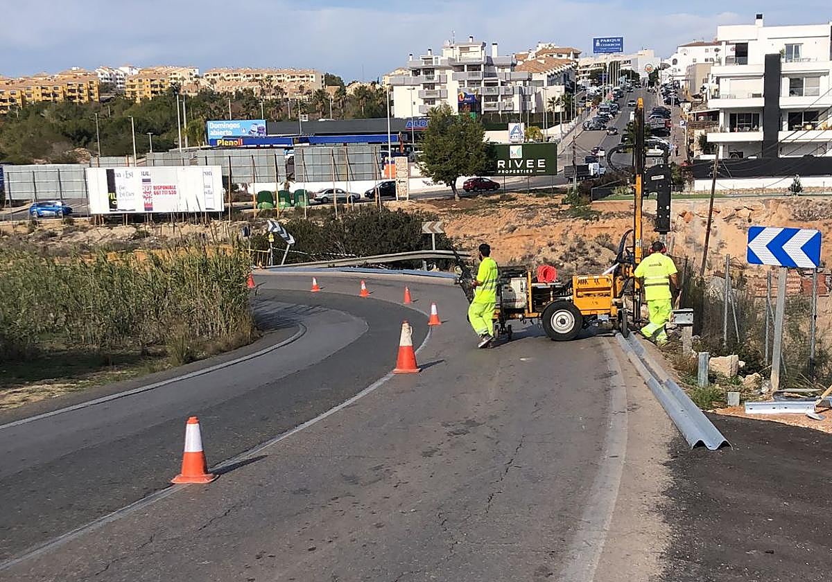 Operarios reparan el guardarraíl en la curva de la carretera de San Miguel.