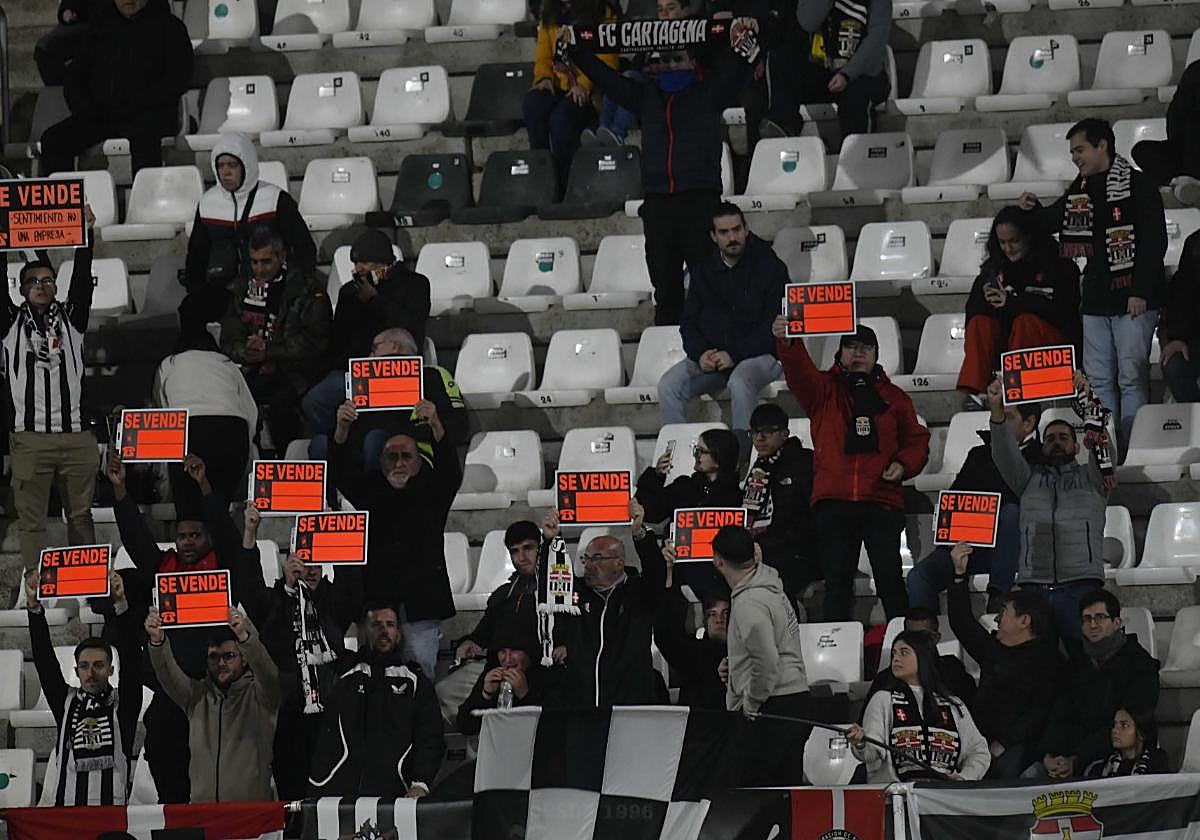 Peñistas del fondo sur, liderados por Pencho Angosto, con carteles de 'Se Vende'.