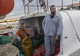 El marinero Francisco Miñarro, entre redes, y su jefe, Antonio Segura, en el arrastrero 'Nuevo Menesteo'.