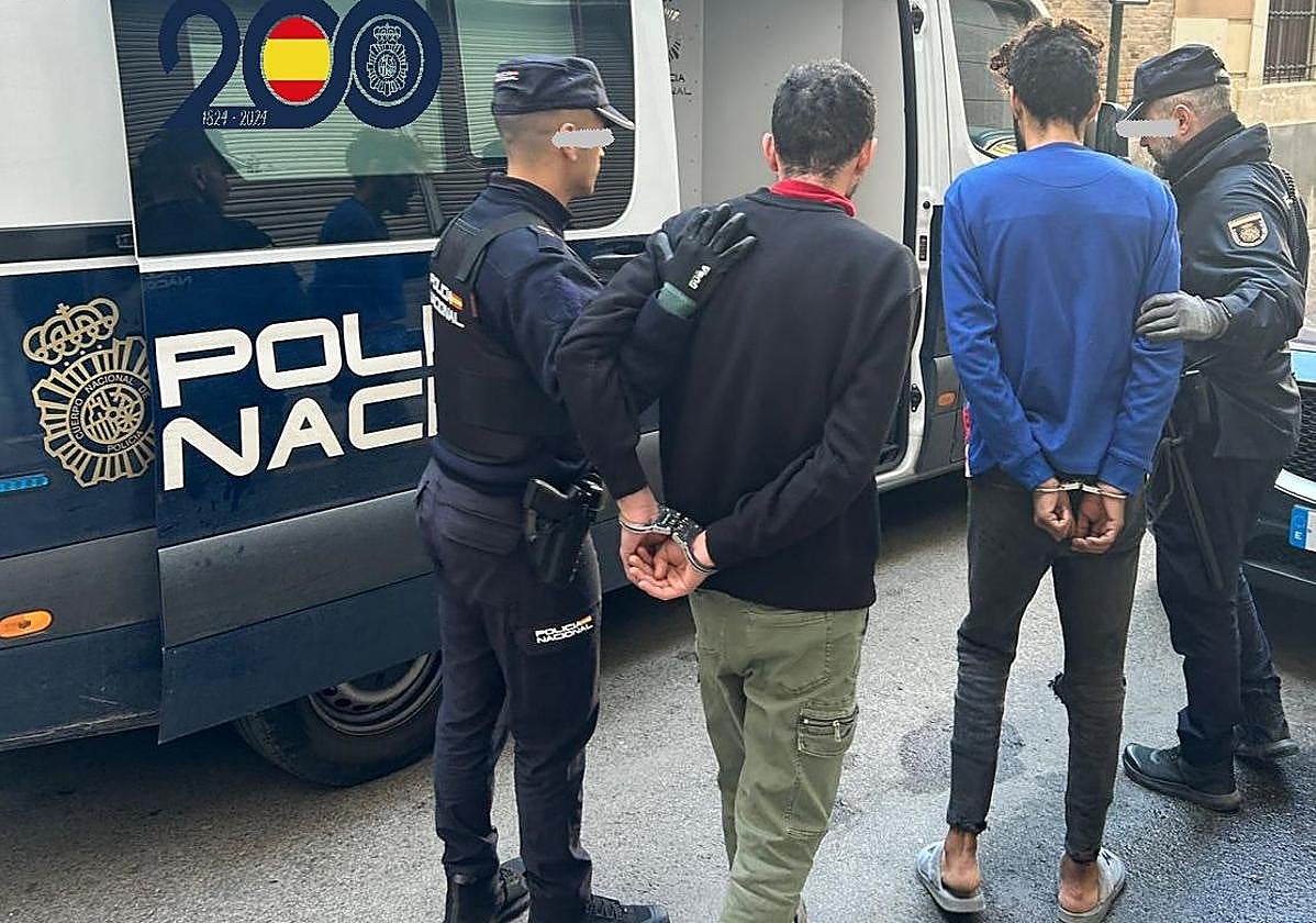 Los agentes custodian a dos de los presuntos autores del robo en un salon de juego de Murcia.