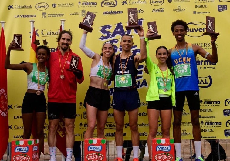 Estanislao Lorencio y Elena Liaño, los ganadores, en el centro del podio de la San Silvestre de Murcia 2024.