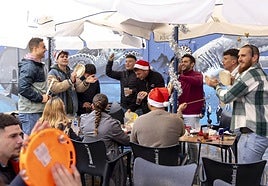 Varios jóvenes festejan el Año Nuevo protegidos de la lluvia en Cartagena.