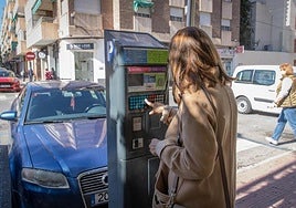 Una usuaria de la zona azul saca a un tiquet de un parquímetro instalado en la plaza San Sebastián.