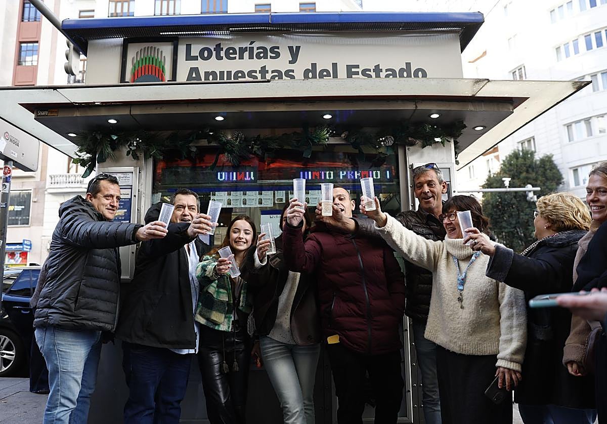 Imagen de archivo de varias personas brindando a las puertas de una administración de lotería.