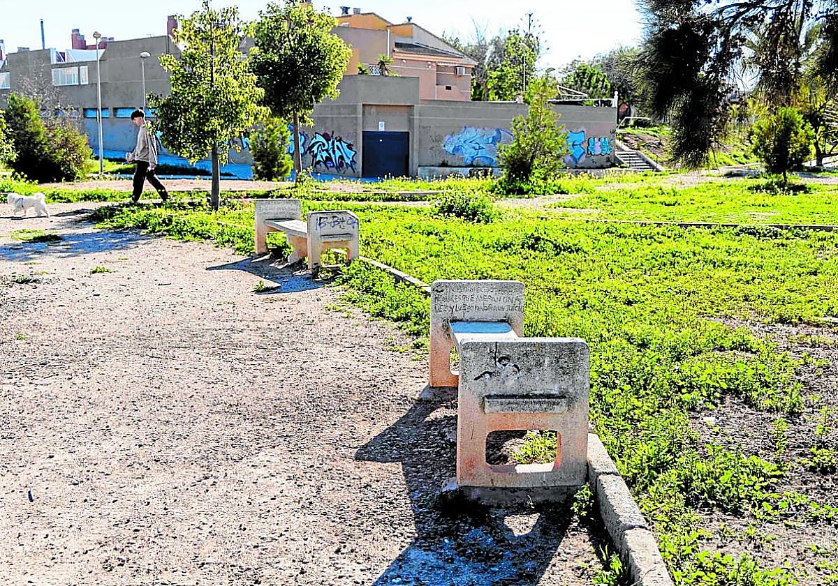 Un chico pasea a su mascota este viernes por el parque de Escipión, en Los Barreros, donde se observa la descuidada vegetación y el estado de las instalaciones.