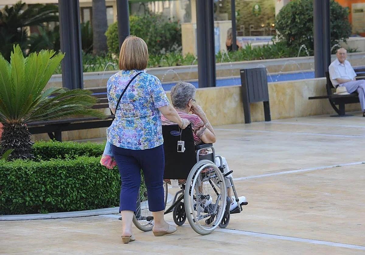 Una mujer ayuda a una persona dependiente en una imagen de archivo.