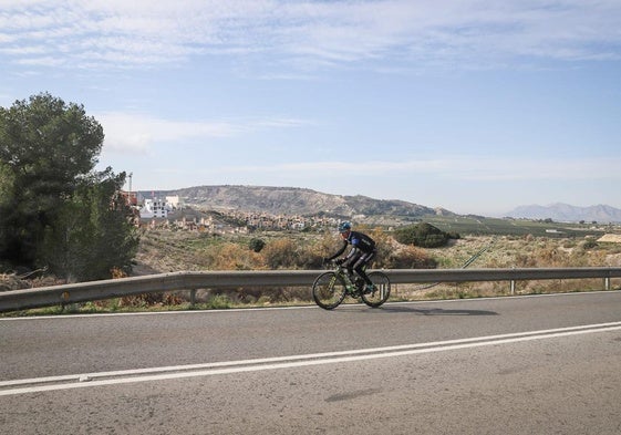 Un ciclista circula por la carretera que une Algorfa con La Finca Golf, al fondo.