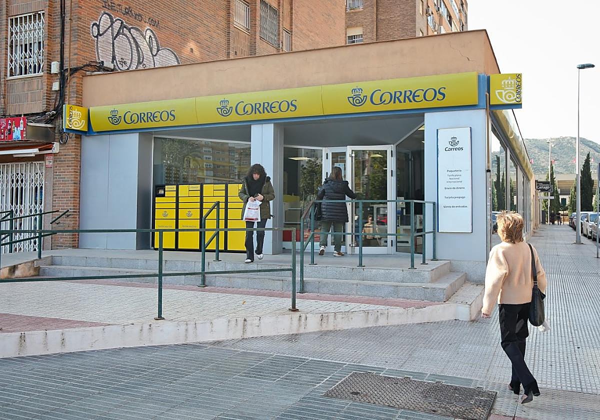 Una mujer entra a la oficina de Correos de la Alameda de San Antón, ayer, mientras otra sale con una bolsa.