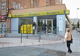 Una mujer entra a la oficina de Correos de la Alameda de San Antón, ayer, mientras otra sale con una bolsa.