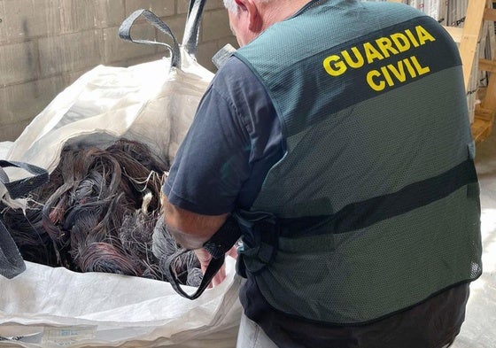 Un agente de la Guardia Civil con el material recuperado.