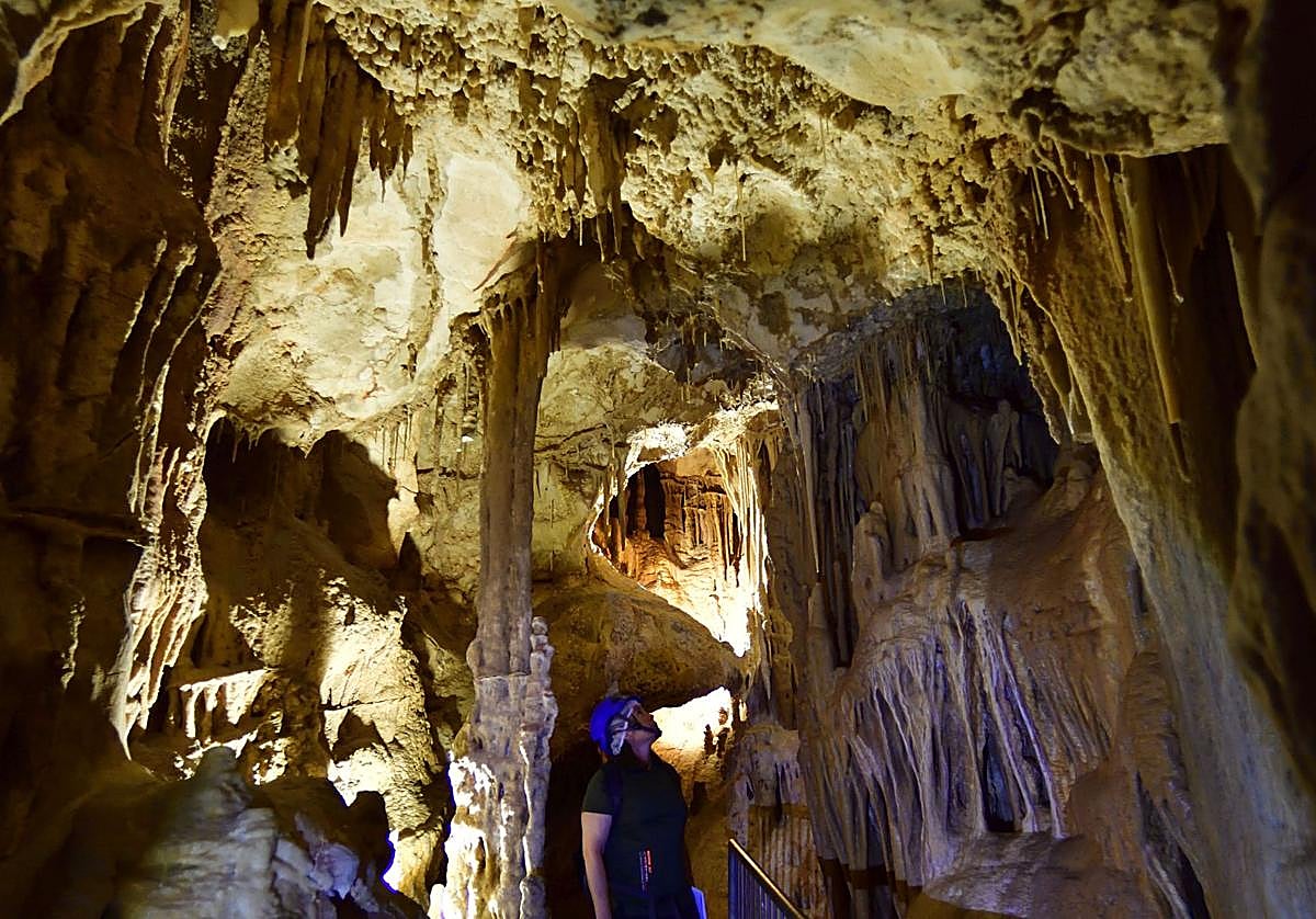 Un visitante observa una formación de estalactitas en el interior de la Cueva del Puerto de Calasparra.