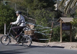 Una persona en bicicleta pasa frente a la entrada a la Cueva del Agua, en Isla Plana, este lunes.