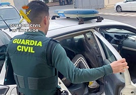 Un agente de la Benemérita con el detenido.