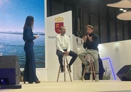 La periodista Sandra Díaz entrevista a Alejandro Valverde y Pedro Acosta, en el escenario del estand institucional en Fitur, este jueves.