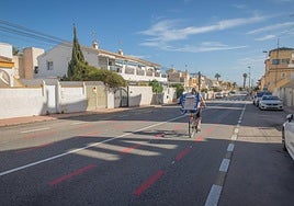 Una mujer circula en bicicleta por la nueva ciclocalle pintada en la avenida Doctor Walksman.