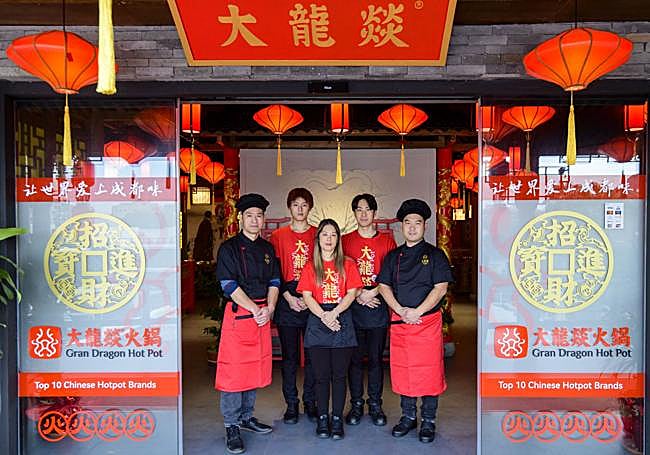 Los miembros de la familia Woo Xia, propietarios de Gran Dragón Hot Pot, en la entrada del local.