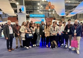 La consejera Carmen Conesa y el director del Instituto de Turismo, con un grupo de estudiantes de Turismo ante el estand de la Región en Fitur.