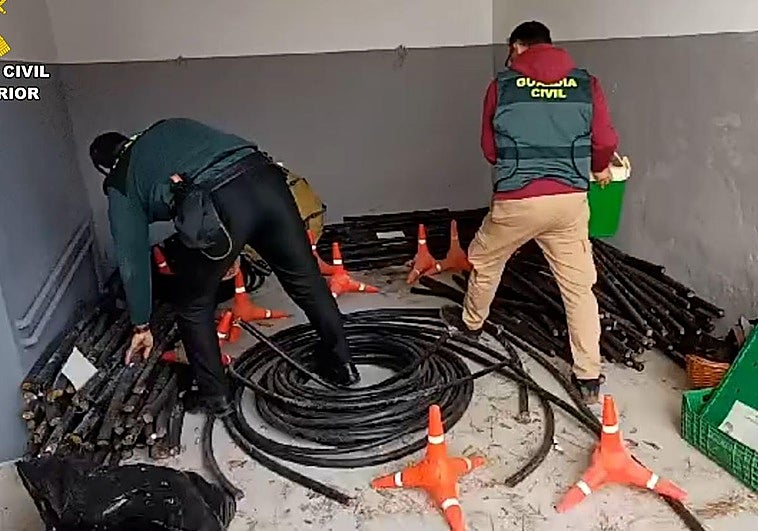 Dos guardias civiles junto a cables de cobre recuperados.