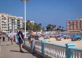 Turistas fotografían el estado de la mar a los pies de la playa de Los Locos.