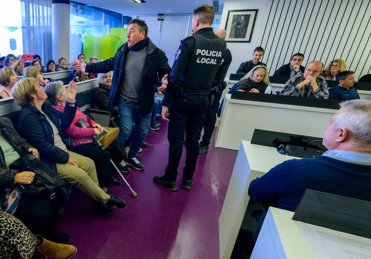 Un vecino es desalojado del pleno del Ayuntamiento de Las Torres de Cotillas por parte de la Policía Local, este jueves por la mañana.